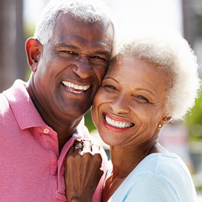 An older couple smiling due to dental crowns and bridges