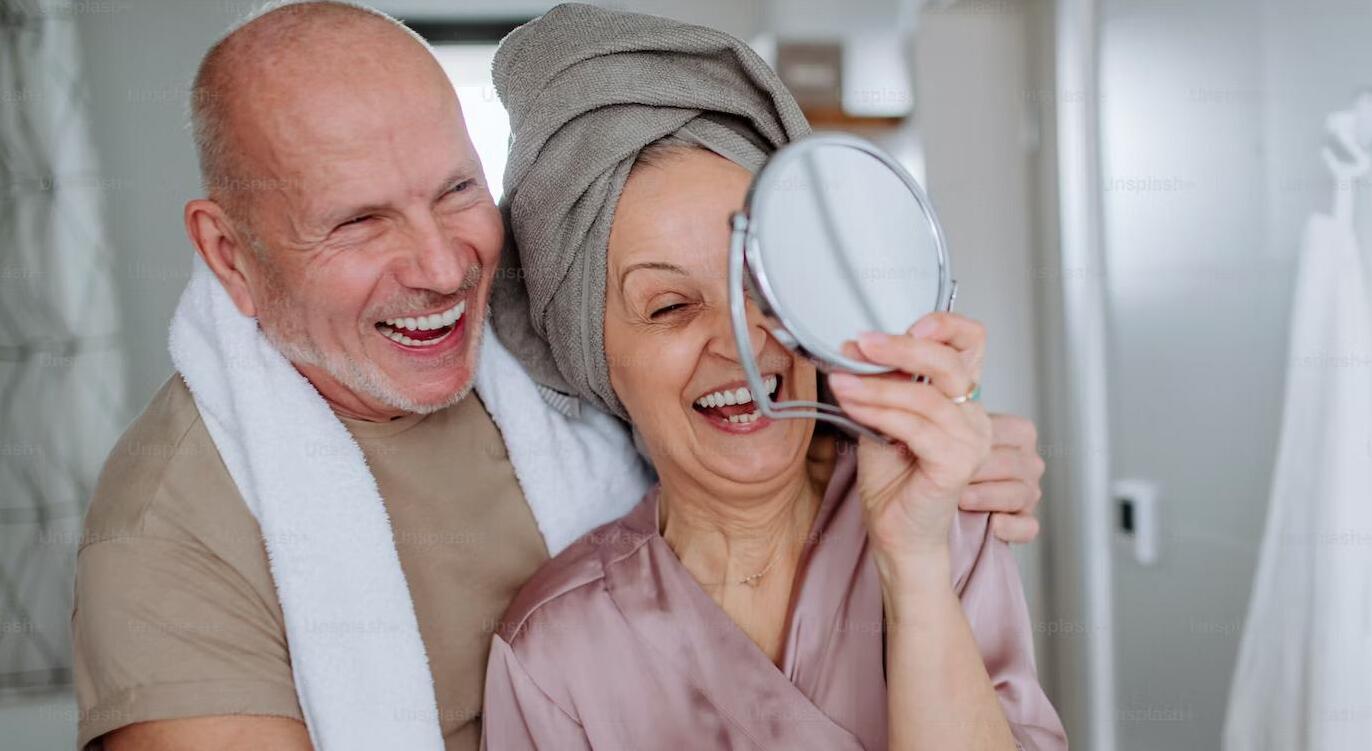 Elderly couple smiling because they found a permanent solutions to their missing teeth. 