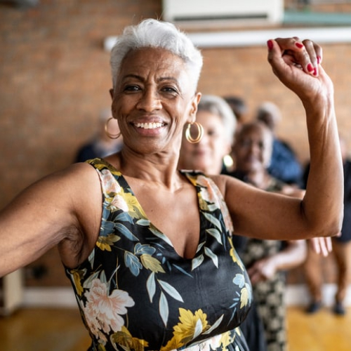 A mature woman with grey hair dances and smiles