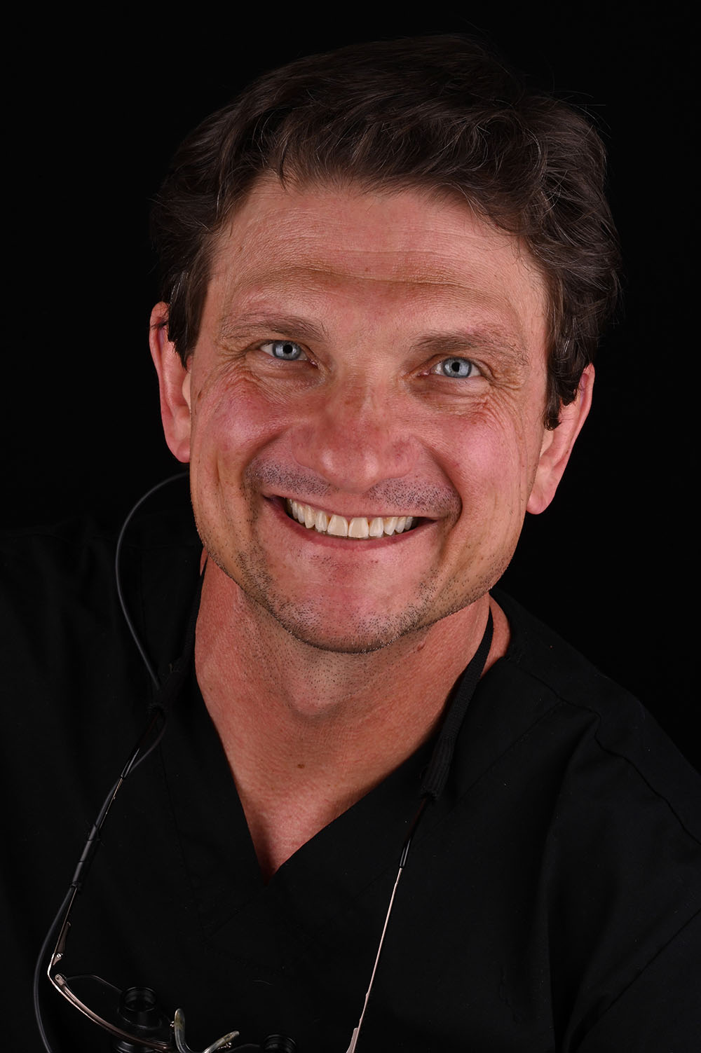 Dr. James Volker smiling, wearing dark scrubs